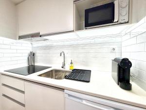 a kitchen with a sink and a microwave at Casa do Castello Chaves in Chaves +2 photos