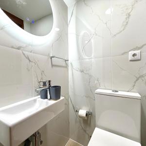 a white bathroom with a sink and a toilet at Casa do Castello Chaves in Chaves