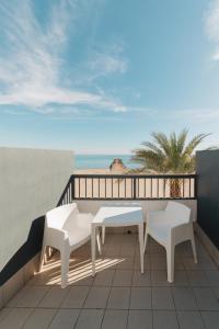 a balcony with a table and two chairs and the ocean at Hotel La Familia in El Campello