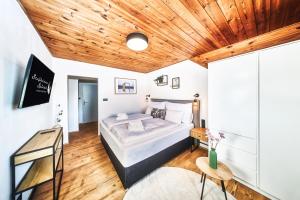 a bedroom with a bed and a wooden ceiling at Stejkárna Špičák in Špičák
