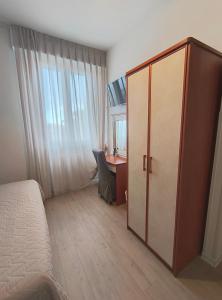 ein Schlafzimmer mit Bett, Schreibtisch und Schrank in der Unterkunft Hotel Marta in Forlì