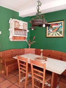a dining room with green walls and a table and chairs at Casa Rural La Torre De Babel in Molinaseca