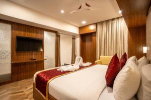 a hotel room with a large bed with red pillows at HOTEL BLUEMOON in Tirunelveli