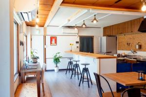 an open kitchen and dining room with tables and chairs at Denim Lodge Nest in Kurashiki
