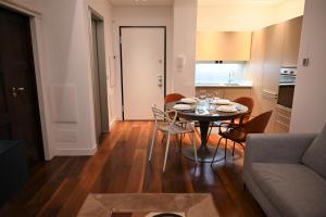 a living room with a table with chairs and a couch at Brera Elegant in Milan