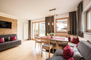 ein Wohnzimmer mit einem Tisch und einem Sofa in der Unterkunft Bachmannhof in Feldthurns