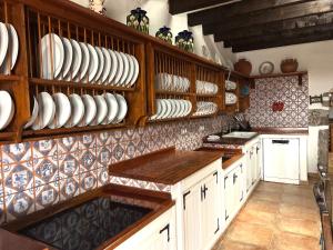 a kitchen with wooden cabinets and plates on the wall at Casa Tara - 5 bedroom, 4 bathroom villa with private pool in Mácher +39 photos