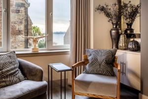 a living room with a chair and a window at Arran Shores Luxury Shorefront Apartment 8 in Lamlash