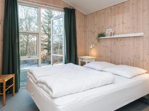 a bedroom with a large white bed and a window at 8 person holiday home in Børkop in Børkop