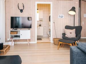 a living room with a television and a chair at 8 person holiday home in Børkop in Børkop