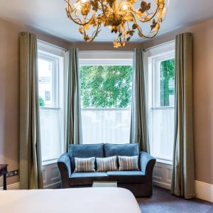 a living room with a couch and a chandelier at The High Field Town House in Birmingham