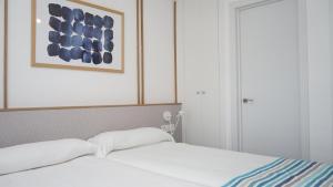 a bedroom with a bed and a picture on the wall at Apartamentos BCL Playa Albir in Albir