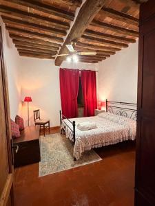 a bedroom with a bed and a red curtain at La casa del colle in Colle di Buggiano