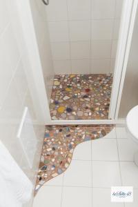 a bathroom with a shower with a tile floor at La Suite 48 in Vietri sul Mare