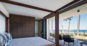 a bedroom with a bed and a view of the ocean at Smart Elegant Villa with Amazing Tropical Views in Toiny