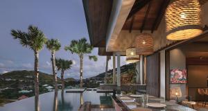 a restaurant with palm trees and a swimming pool at Smart Elegant Villa with Amazing Tropical Views in Toiny