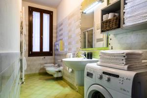 ein Badezimmer mit Waschmaschine und Waschbecken in der Unterkunft Cà Sant`Angelo in Venedig