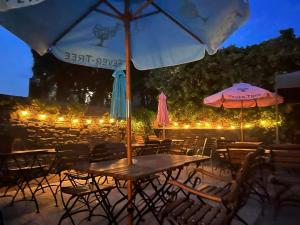 a wooden table with chairs and umbrellas at night at Fishermans Tavern in Dundee