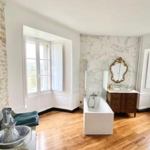a white bathroom with a sink and a mirror at Château de la Pervenchère gîte Marin in Casson