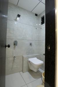 a white bathroom with a toilet and a shower at Hotel Bansi Palace in Dwarka