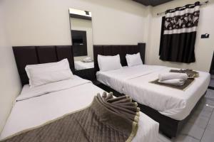 two beds in a hotel room with towels on them at Hotel Bansi Palace in Dwarka