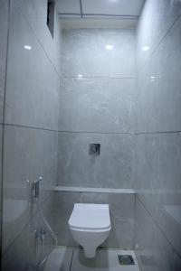 a white bathroom with a toilet and a shower at Hotel Bansi Palace in Dwarka