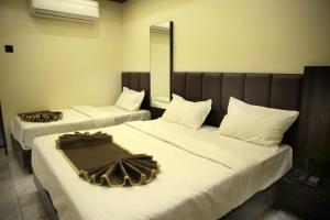 two beds in a hotel room with white sheets at Hotel Bansi Palace in Dwarka +13 photos