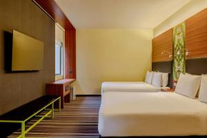 a hotel room with two beds and a tv at Aloft by Marriott Asuncion in Asunción +24 photos
