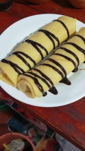 a white plate with three wrapped bananas with chocolate sauce at Vino lanka in Trincomalee