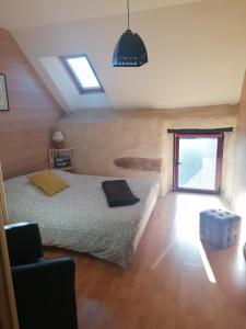 a bedroom with a bed and a ceiling with skylights at Gîte Kersonan in Saint-Jean-Brévelay