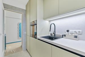a kitchen with white cabinets and a sink at Appartement à Belair in Hollerich