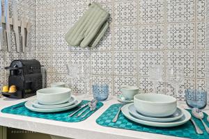 a kitchen counter with a table with plates and silverware at Appartement à Belair in Hollerich +6 photos
