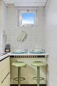 a kitchen with two green stools at a counter at Appartement à Belair in Hollerich
