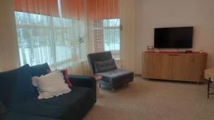 ein Wohnzimmer mit Sofa, Fernseher und Sessel in der Unterkunft Rēzijas in Ķegums