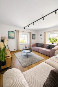 a living room with two couches and a table at Dablin 9 - Dom w górach z gorącą balią, blisko szlaków i wyciągów in Korbielów