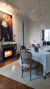a dining room with a table and a fireplace at La Charmeraie d'Aumâtre in Aumâtre