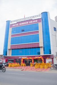 a building with yellow tables and chairs in front of it at Hotel Rinkesh Grand in Aurangābād