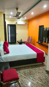a bedroom with a large bed and two chairs at Hotel Rinkesh Grand in Aurangābād +20 photos