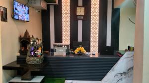 a room with a desk with a clock on the wall at Hotel Rinkesh Grand in Aurangābād