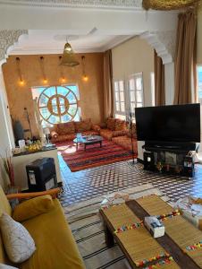 a living room with a couch and a tv at CHÂTELET Ouarzazate in Tabount