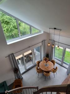 a dining room with a table and chairs and windows at freistehendes Ferienhaus mit Sauna und Badefass in Sehestedt