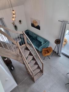 a living room with a couch and a staircase at freistehendes Ferienhaus mit Sauna und Badefass in Sehestedt