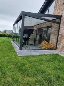 a screened in patio with chairs and a grill at freistehendes Ferienhaus mit Sauna und Badefass in Sehestedt