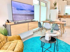 a living room with a large tv and a table at Idyllisches Ferienhaus mit Spielzimmer und Garten in Sehestedt