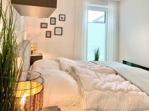a bedroom with a bed with white sheets and a window at Idyllisches Ferienhaus mit Spielzimmer und Garten in Sehestedt