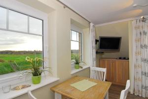 a dining room with a table and a window at Wodan, Whg 2 in Tinnum