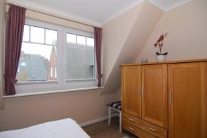 a bedroom with a dresser and a large window at Wodan, Whg 2 in Tinnum +5 photos