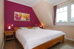 a bedroom with a bed and a purple wall at Wodan, Whg 2 in Tinnum