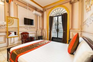 a bedroom with a bed and a tv and a window at Collection O Bao Duy Hotel in Ho Chi Minh City