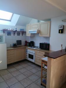 a kitchen with white cabinets and a stove top oven at Gîte Kersonan in Saint-Jean-Brévelay